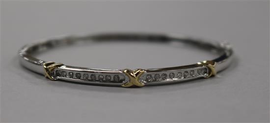 A modern 14ct white gold and channel set diamond hinged bangle, with yellow gold x motifs, gross 9.8 grams.